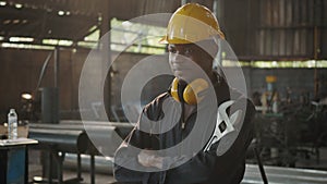 Engineer standing holding wrench tools and arms crossed at work in the industry