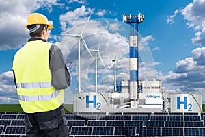 Engineer with tablet computer on a background of Hydrogen factory.