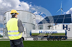 Engineer with tablet computer on a background of Hydrogen factory.