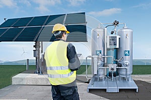 Engineer with tablet computer on a background of Hydrogen factory.