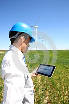 Engineer with tablet in wind turbine field