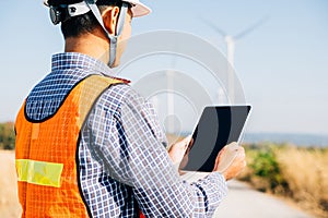 Engineer with tablet at windmill farm
