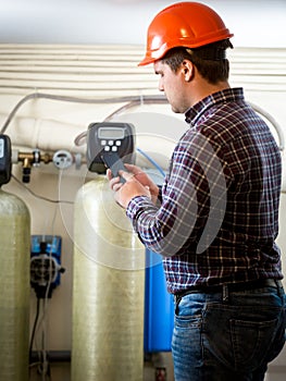 Engineer taking meter readings from industrial pumps at factory