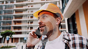 Engineer talking on phone. Architect using phone on construction site. Foreman phone call control process. Construction worker