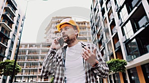 Engineer talking on phone. Architect using phone on construction site. Foreman phone call control process. Construction worker