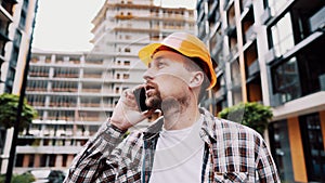 Engineer talking on phone. Architect using phone on construction site. Foreman phone call control process. Construction worker