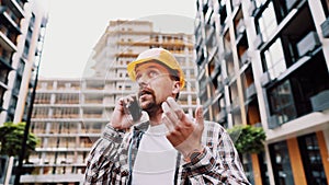 Engineer talking on phone. Architect using phone on construction site. Foreman phone call control process. Construction worker