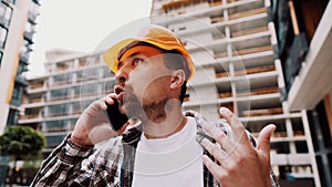 Engineer talking on phone. Architect using phone on construction site. Foreman phone call control process. Construction worker