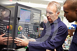 Engineer Teaching Apprentice To Use Computerized Lathe