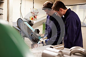 Engineer Teaching Apprentice To Use Grinding Machine