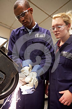 Engineer Teaching Apprentice To Use Grinding Machine