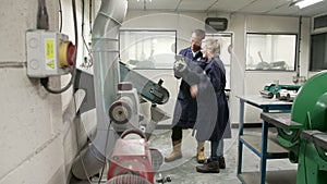 Engineer Teaching Apprentice To Use Grinding Machine