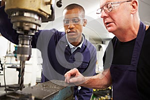 Engineer Teaching Apprentice To Use Milling Machine photo