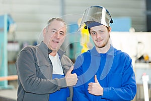 Engineer teaching apprentice to use tig welding machine