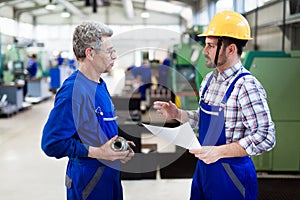 Engineer Teaching Apprentices To Use Computerized cnc metal processing machines