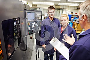 Engineer Teaching Apprentices To Use Computerized Lathe