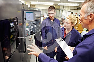 Engineer Teaching Apprentices To Use Computerized Lathe