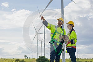 Engineer team man and woman field working together survey plan construction wind turbine clean power generator