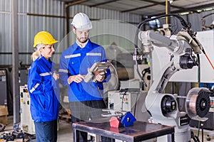 Engineer team man and woman working together training help support work with robot welding machine service