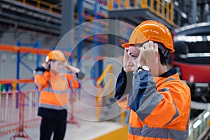 Engineer team worker check safety helmet clothing for work electric train service depot transport industry factory technician