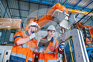 engineer team worker working with robot arm assembly machine in modern metal heavy industry factory