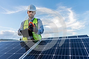 engineer technician checking output voltage level of inverter, electrician measuring power on solar panels