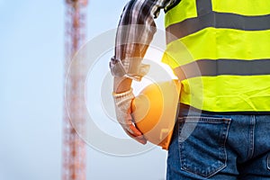 Engineer technician holding helmet in construction site and construction site worker background safety first concept