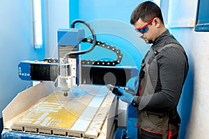 Engineer or technician operating with CNC milling machine in lab. Aircraft capable of GPS surveillance.