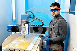 Engineer or technician operating with CNC milling machine in lab. Aircraft capable of GPS surveillance.