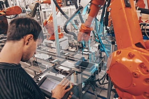 Engineer, technician working with automatic robot in automotive industrial, smart factory, automated workplace