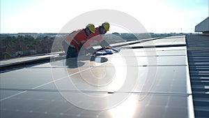 Engineer and technician working on the solar panel on the warehouse roof to inspect the solar panels