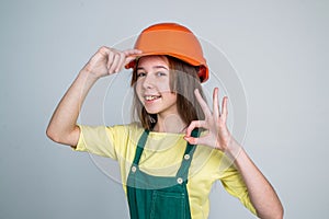 engineer teen is construction worker. international workers day. electrician show ok gesture. girl in helmet plays