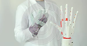Engineer is testing robotic prosthesis hand which repeats the movement of his hand in glove with sensors. Muscle