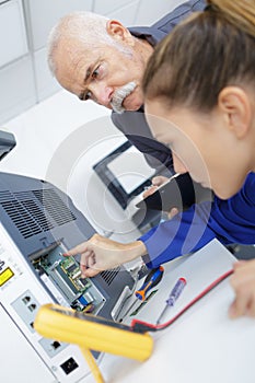 Engineer training female apprentice on cnc machine