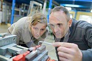 Engineer training female apprentice on milling machine