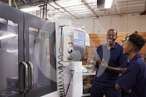 Engineer Training Young Male Apprentice On CNC Machine