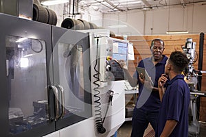 Engineer Training Young Male Apprentice On CNC Machine