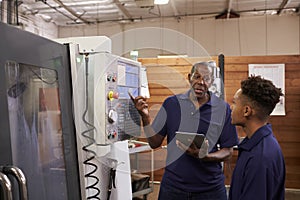 Engineer Training Young Male Apprentice On CNC Machine