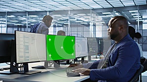 Engineer using green screen computer, working in server farm photo