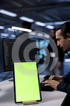 Engineer using isolated screen tablet to do maintenance in server hub