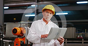 Engineer using laptop in bottle factory