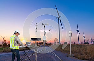 Engineer using laptop computer collect data with meteorological instrument to measure the wind speed, temperature and humidity and