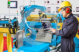 Engineer using laptop computer for control automatic robotic