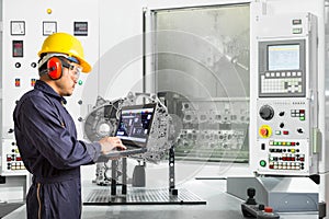 Engineer using laptop computer control automotive CNC machine in automotive industry, Smart factory concept