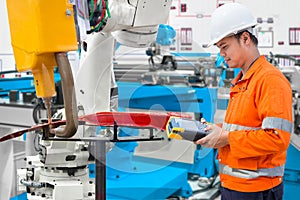 Engineer using laptop computer maintenance robot grip automotive workpiece, Industry 4.0 concept