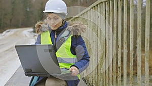 Engineer using laptop PC on bridge renovation