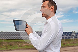 Engineer Using Laptop At Solar Panels Plant Field