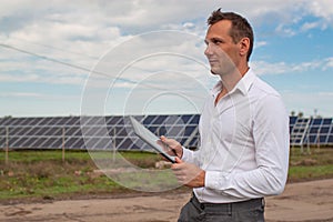 Engineer Using Laptop At Solar Panels Plant Field