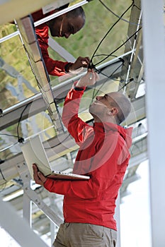 Engineer using laptop at solar panels plant field