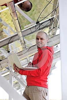 Engineer using laptop at solar panels plant field
